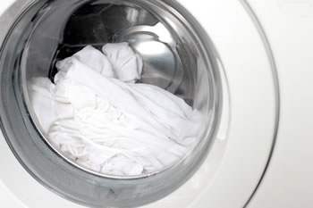 máquina de lavar com roupa branca