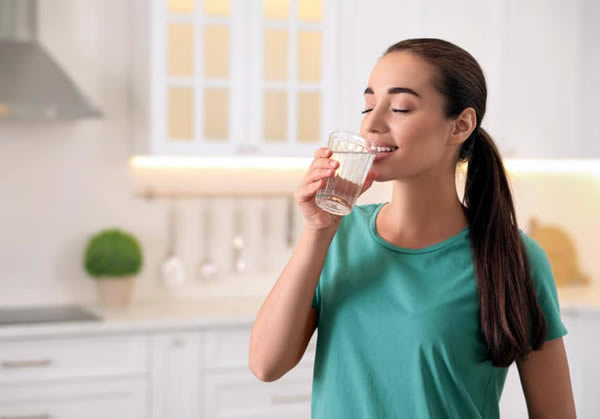 diferença entre purificador e filtro de água - mulher bebendo água